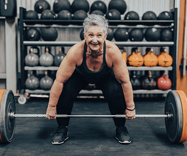 Strong woman prepares to lift weights at gym