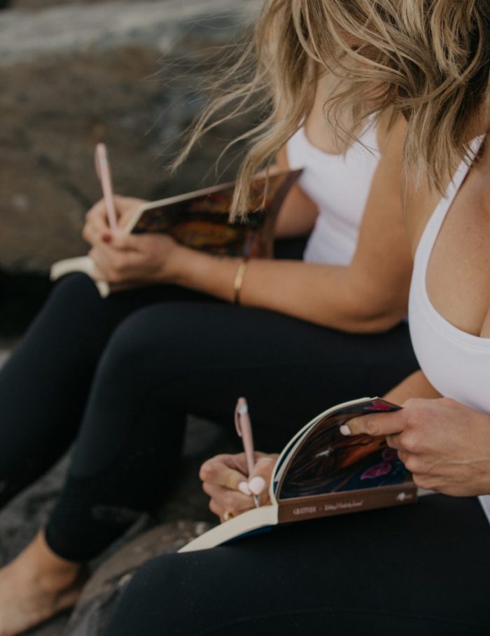 Libby Trickett and Paula Hindle are journaling on the beach.